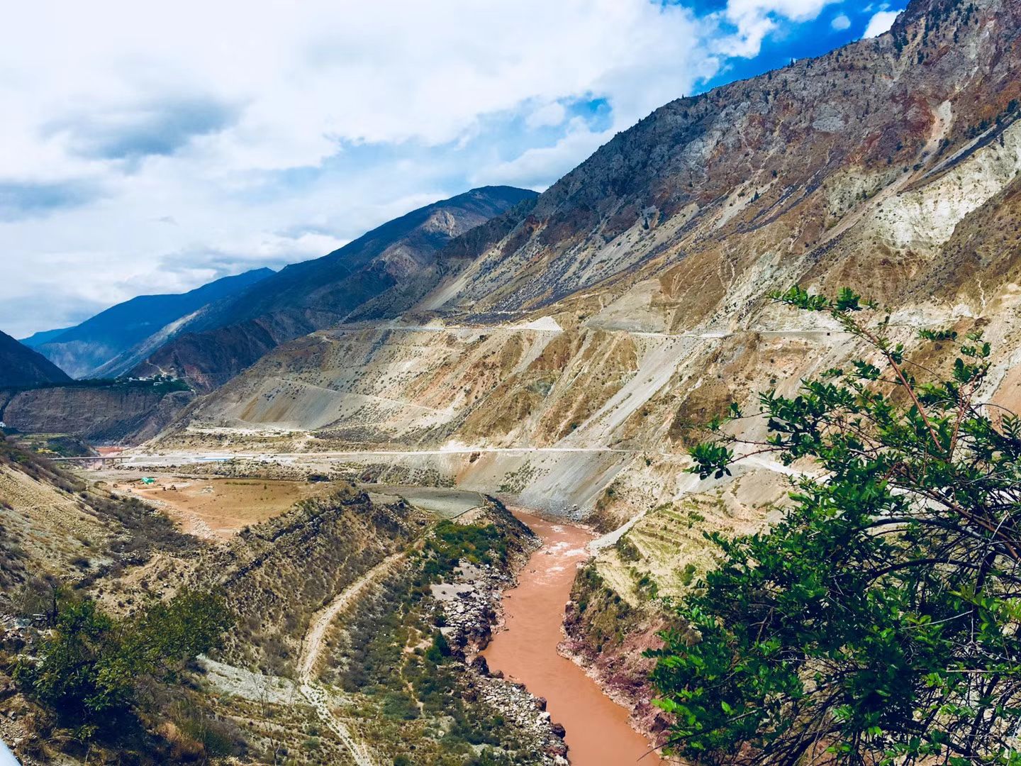 Une route serpentant le long d’une gorge profonde au-dessus d’une rivière brune